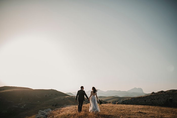 Drone wedding photo of a couple on a hill at sunset
