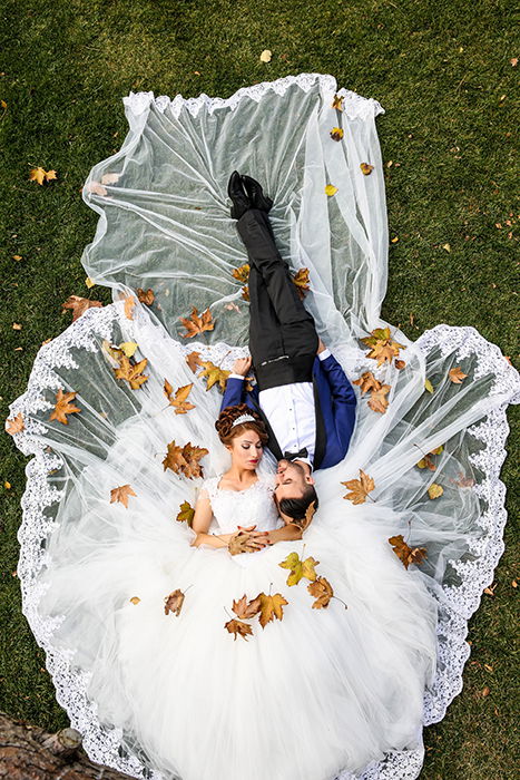 Drone wedding photo of the couple lying in the grass