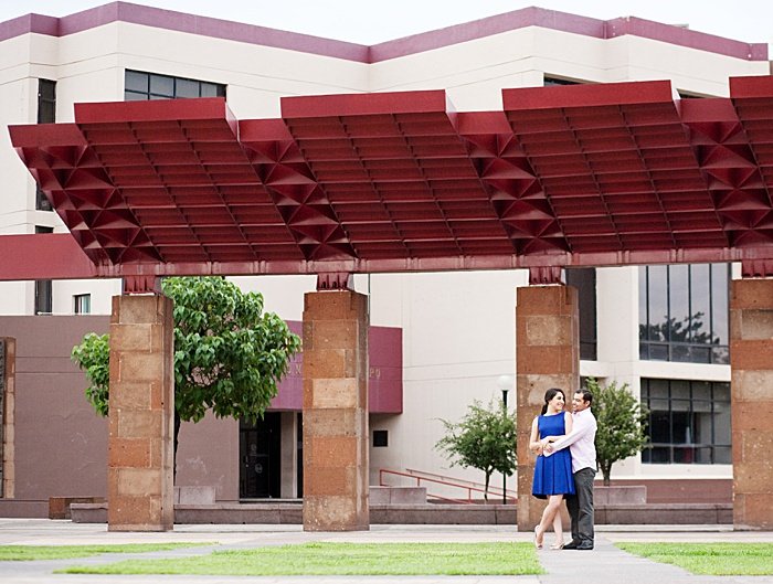 Couple hugging in front of a building for an engagement photo session