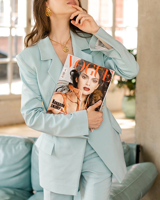 Photo of a woman in blue suit holding a Vogue magazine