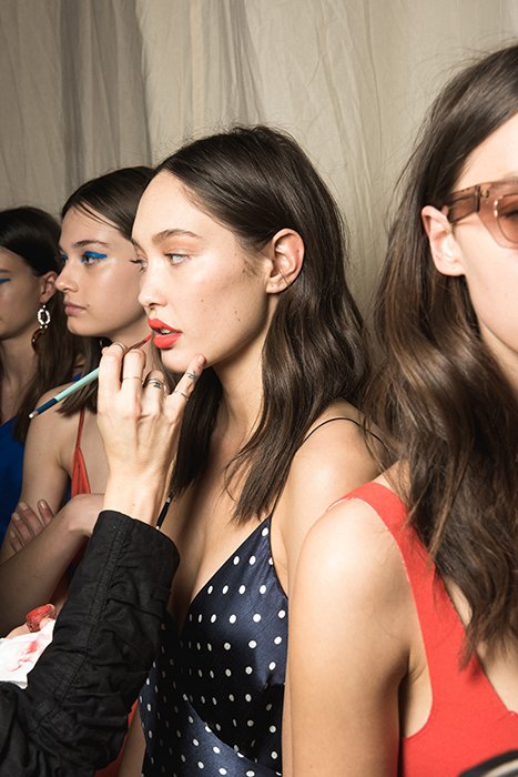 Werk photo of models getting make-up before a runway show