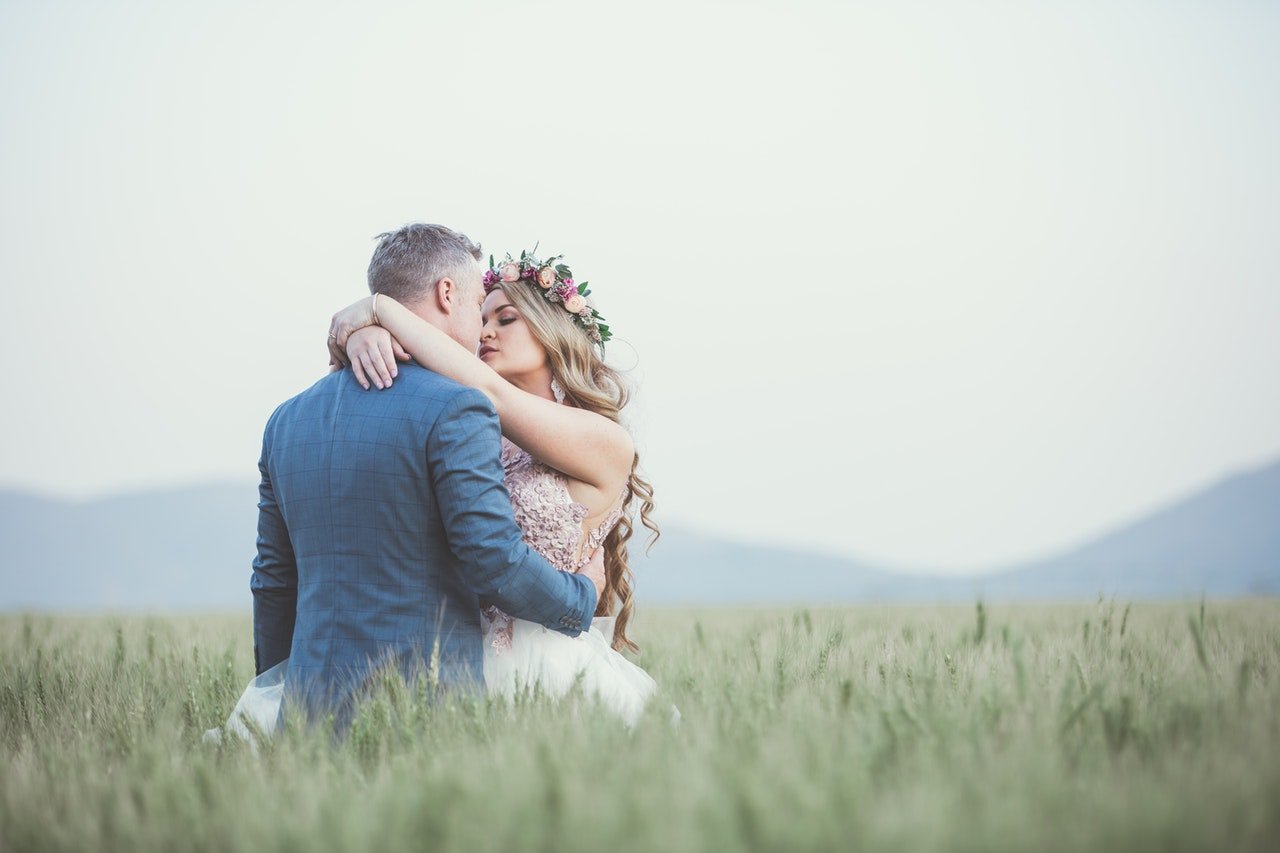 A wedding photography shot of a bride and groom in a field 