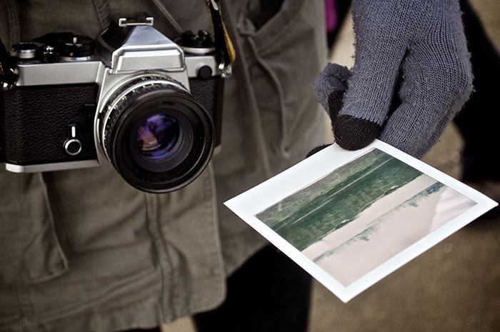 Photo of a photographer holding a Polaroid picture