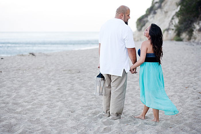 Romantic portrait of a couple trying engagement photo poses on the beach