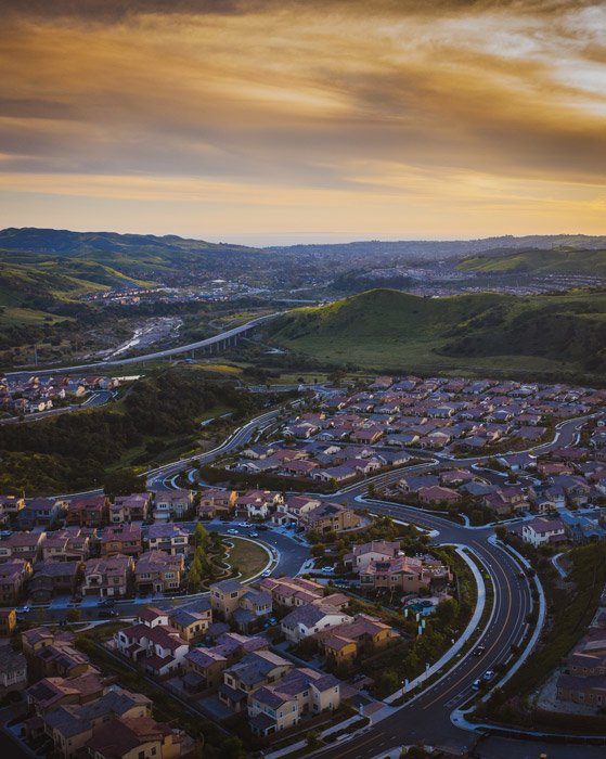 Drone photo of a city with hills at sunset