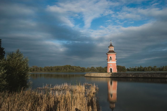 A pink tower next to a lake 