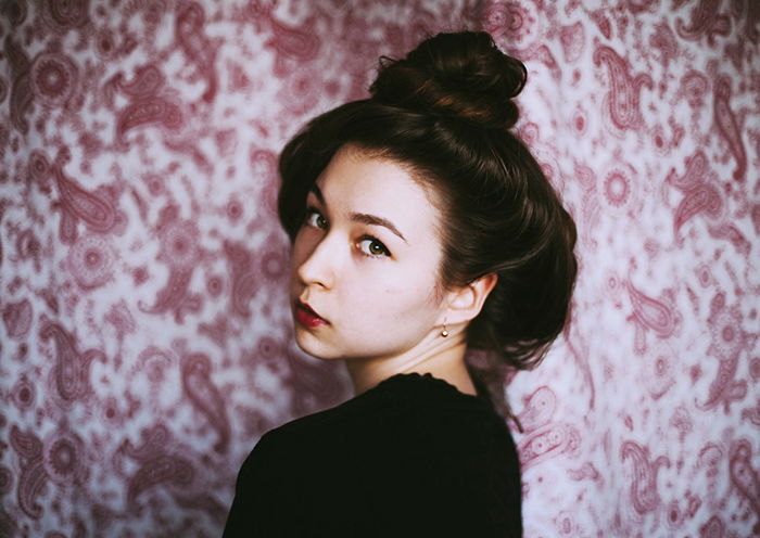 A girl posing in front of a patterned background