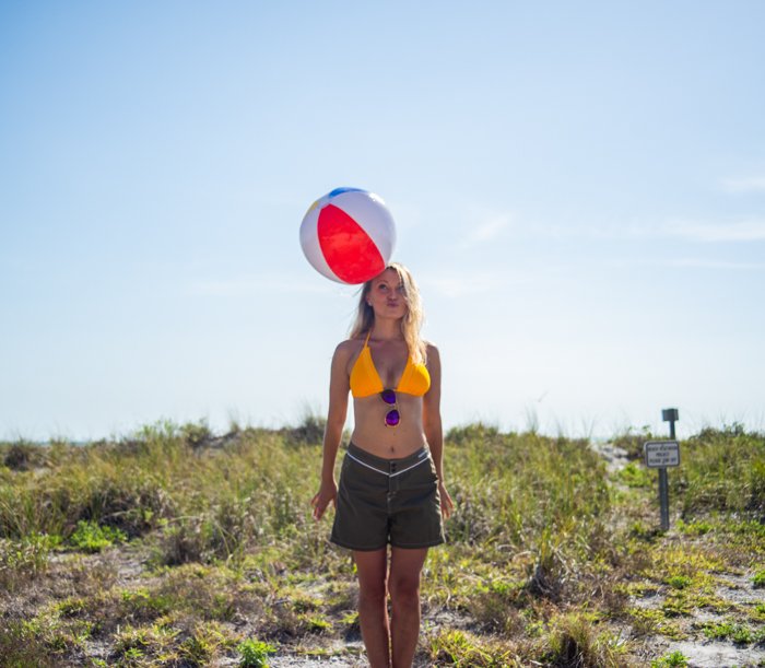outdoor portrait of a female model playing with a beach ball