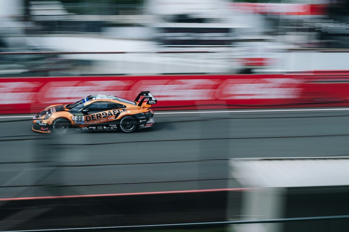 Panning a race car speeding on a race track with background and foreground blur as an example of motorsports photography