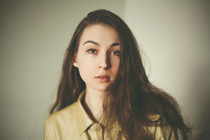 professional headshots girl posing indoors in front of a white wall 1