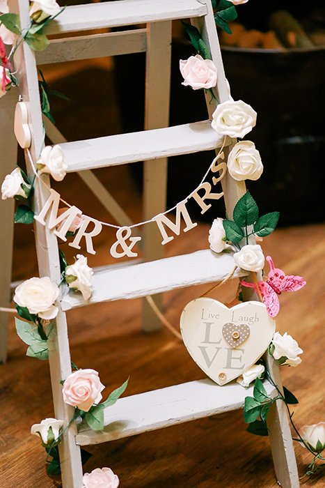 a ladder decorated with flowers and lettering as wedding photography props