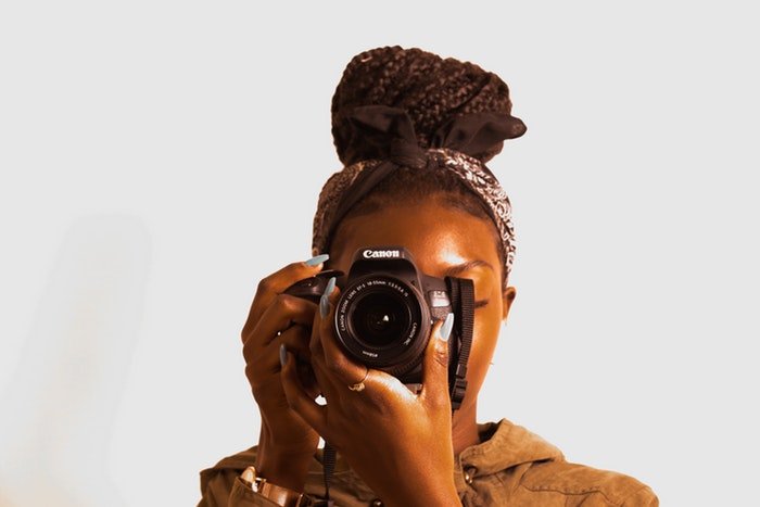 A woman holding a camera with a zoom lens 