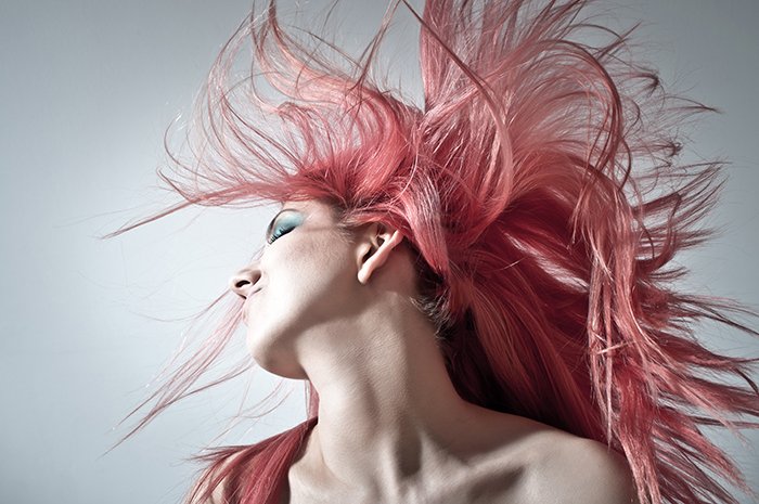 A woman tossing her head back with hair flying using hair portrait lighting