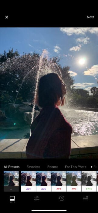Photo of a woman in front of a fountain