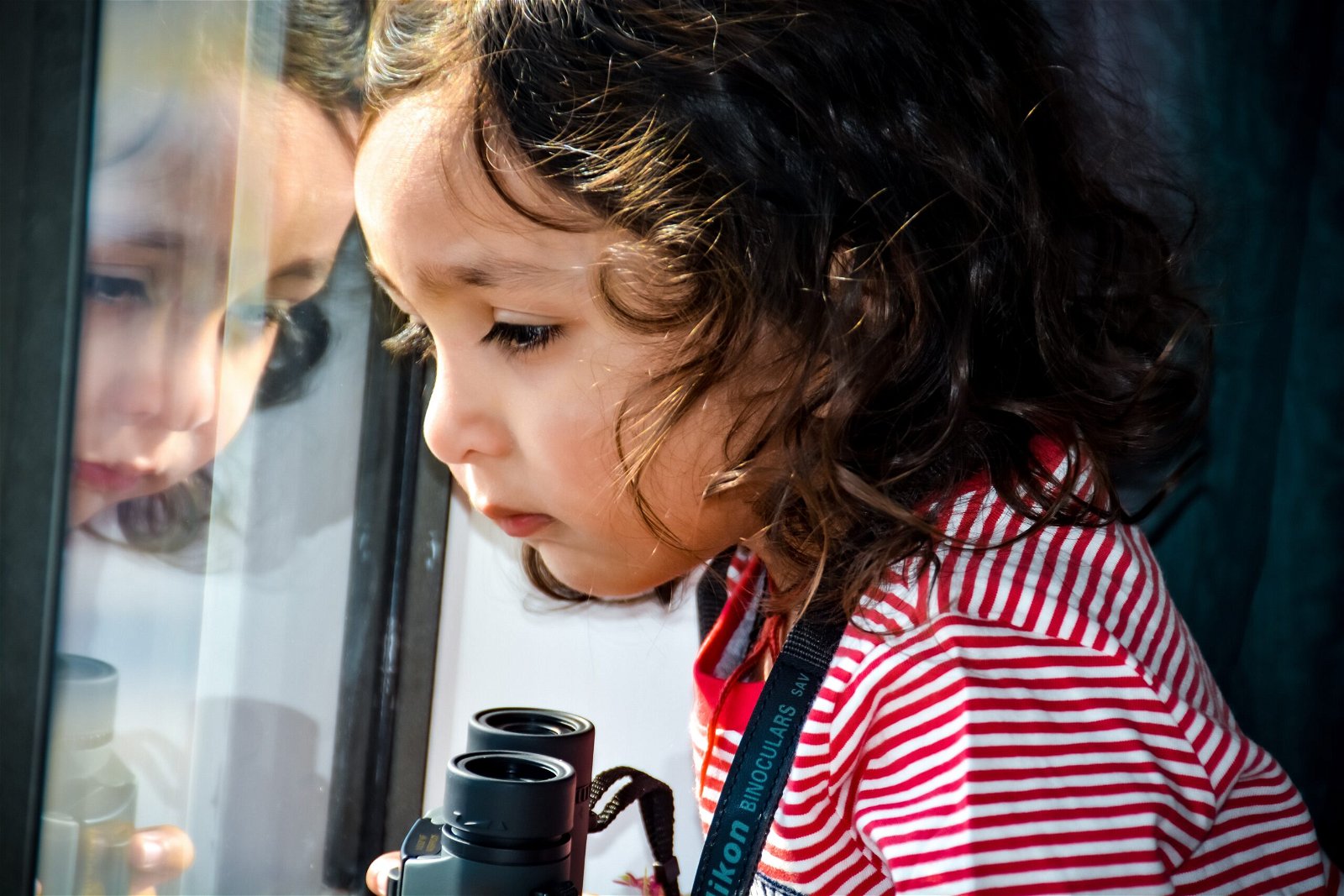 A child looking out the window with binoculars for a kids photo pose
