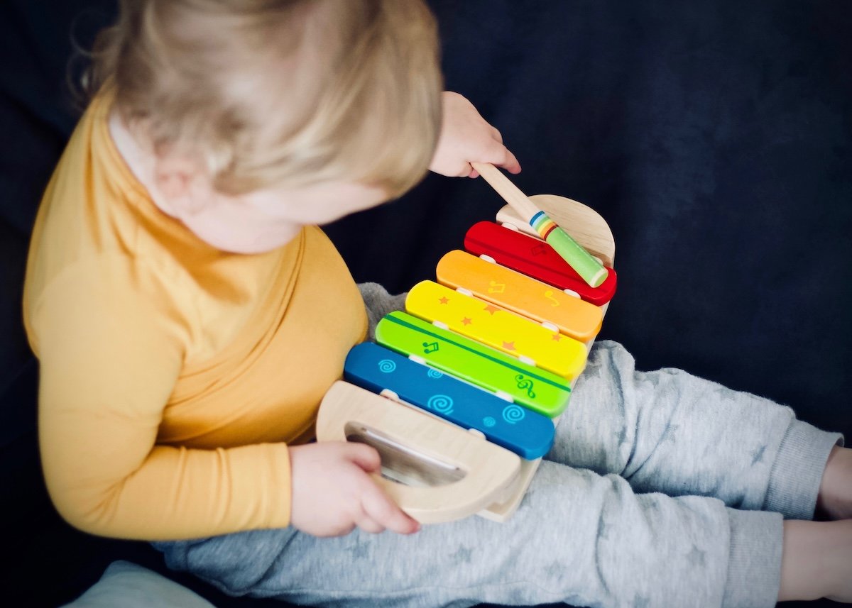A child playing with a xylophone on a couch for a kids photo pose