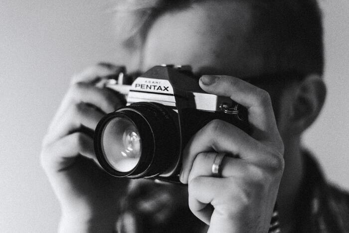 Black and white photo of a guy holding a camera