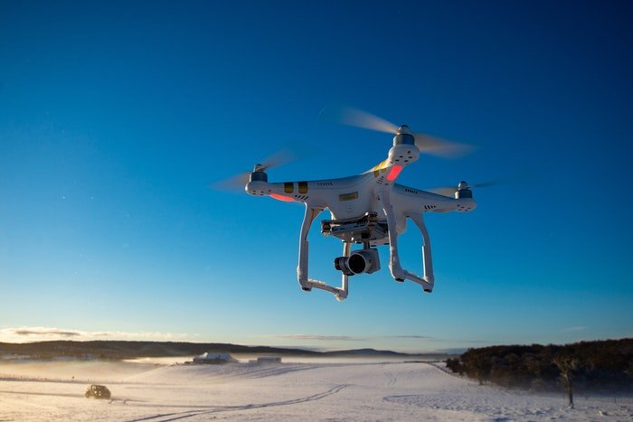 A drone flying above a snowy field