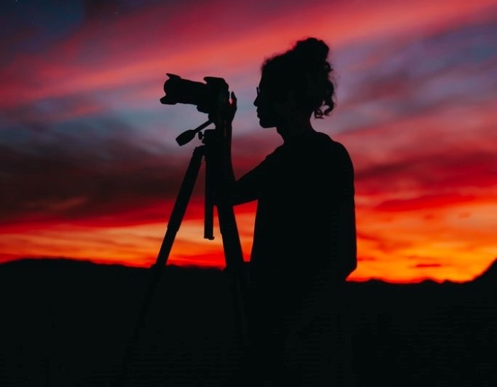 silhouette of woman holding camera at night