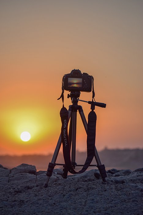 Photo of a camera on a tripod at sunset