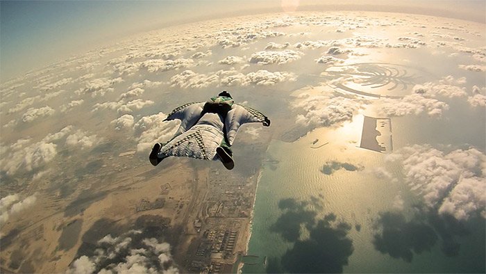 A man flying in a skydiving suit above the clouds 