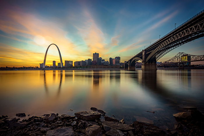 A the cityscape of St. Louis and the Gateway Arch at sunset