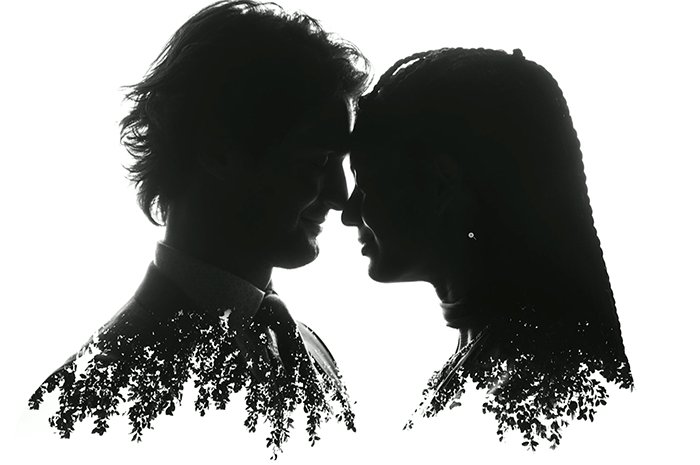 black and white photo of a man and a woman touching foreheads