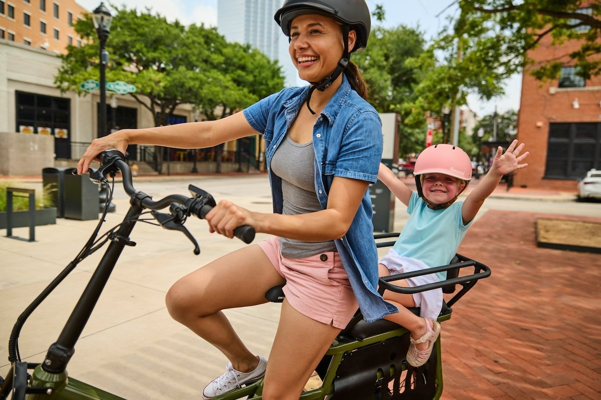 A posed action photo of a mother and child on a bike to show camera settings