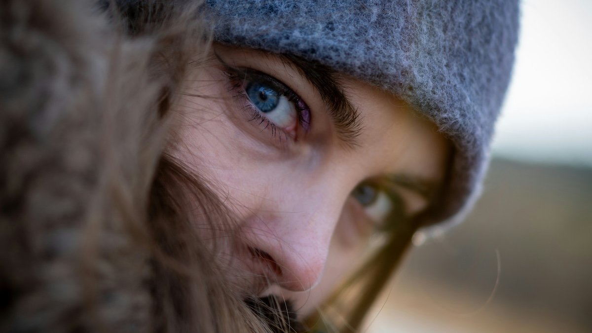 A close-up portrait of a person's eye with a wide aperture and shallow depth of field for camera settings