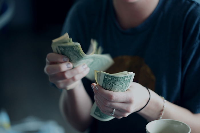 Woman counting dollar bills 