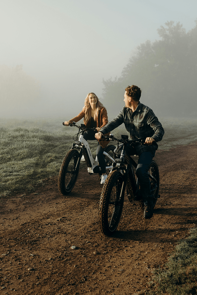 A couple on road bikes with fog in the background for couple poses