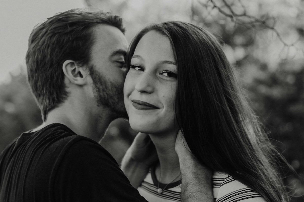 A man kissing a woman on the cheek for couple poses