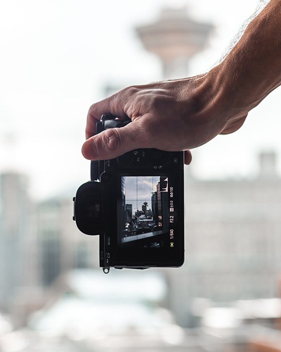 A hand holding a camera and taking dolly zooms of a cityscape