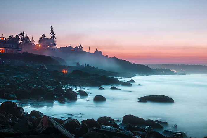 A misty coastal landscape at sunset