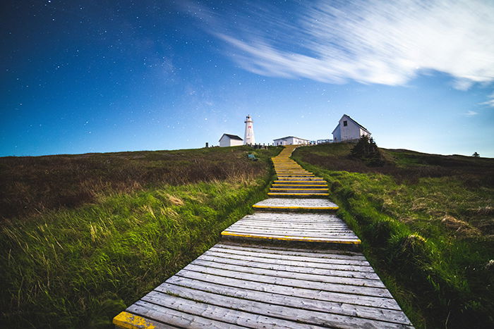 Wooden steps leading to a house on a grassy hill