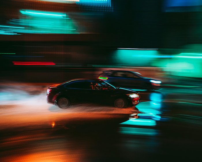 Blurry colored lights around moving cars 