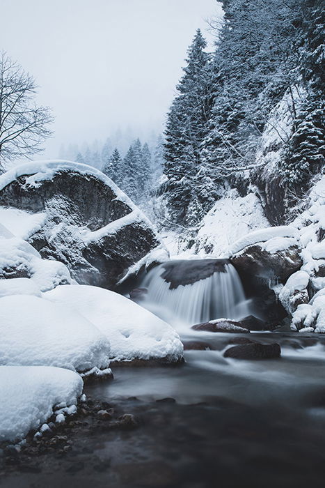 A waterfall among a snowy landscape