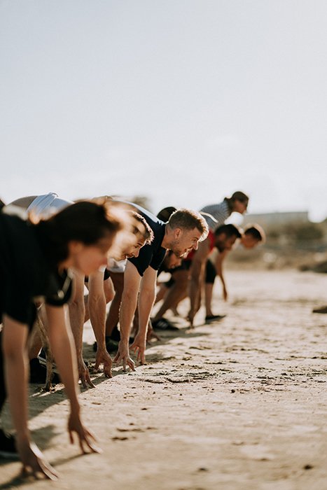 A line of people working out on the beach