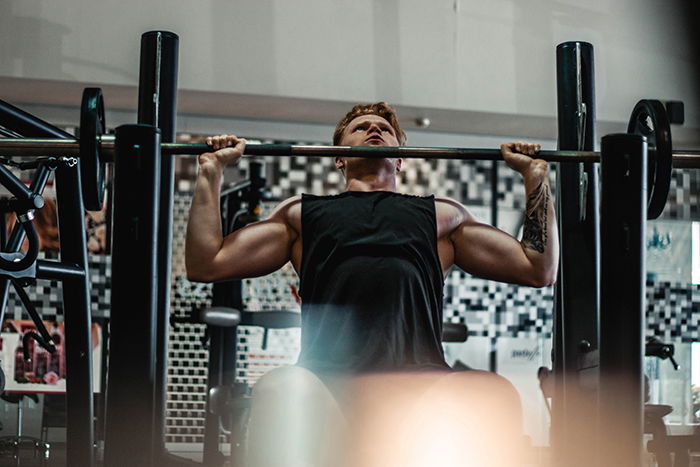 Premium Photo | Tall athletic woman posing in the gym on a bench with  dumbbells. biceps pumping.