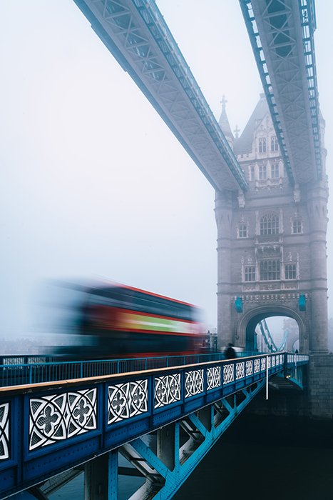 A blurred bus moving over a bridge