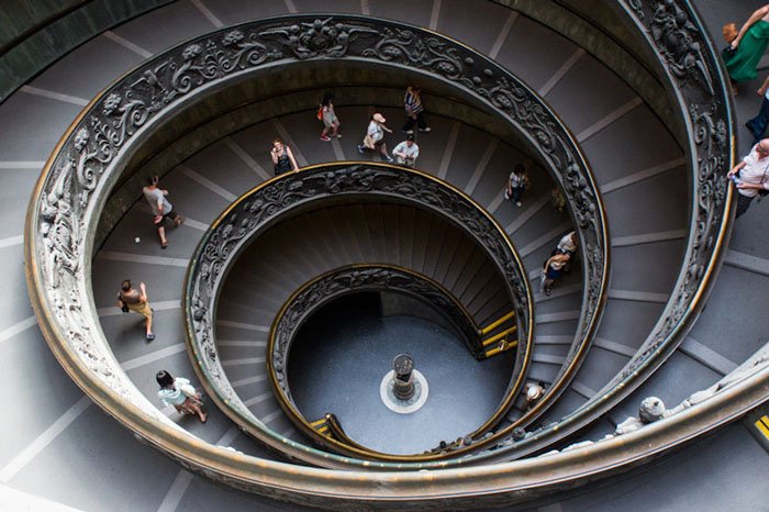 Photo of a spiral staircase with people walking 