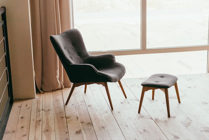 A grey chair and stool indoors