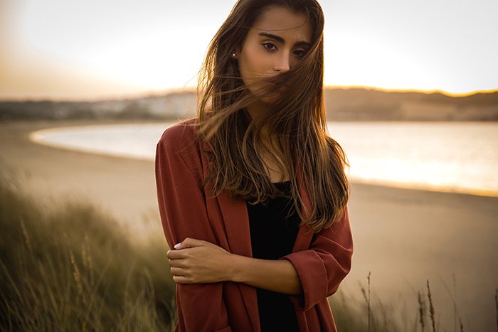 Portrait of a beautiful woman on the beach during golden hour.