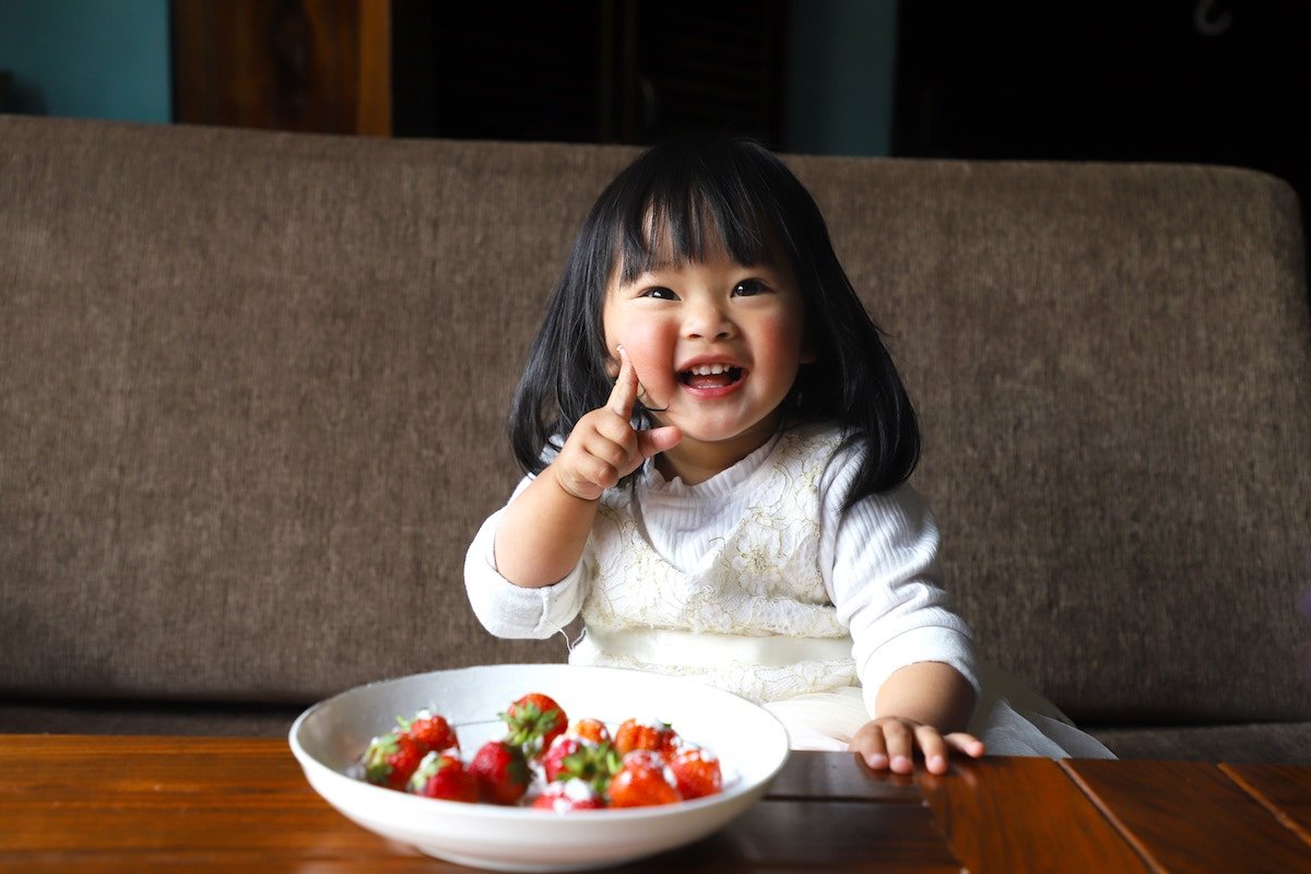 Toddler sitting at a table with a bowl of food
