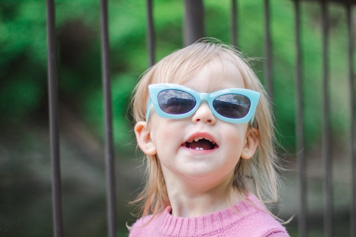 Toddler smiling and wearing sunglasses