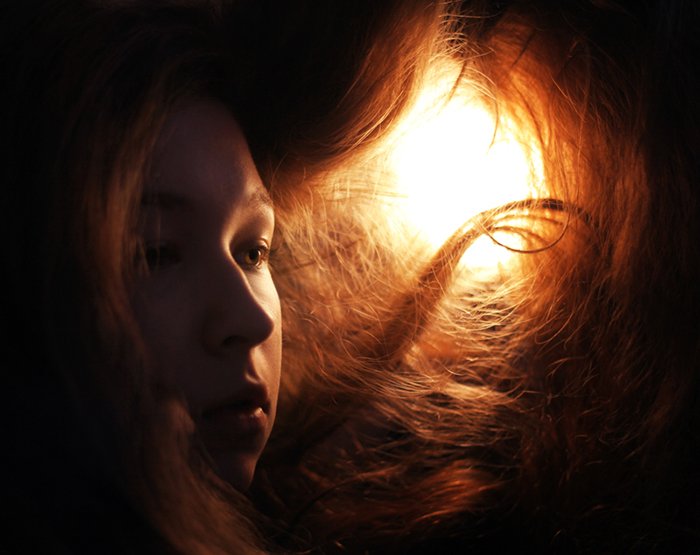 Portrait photo of a girl with red hair in tungsten light