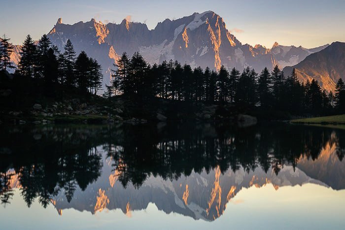 Beautiful long exposure of trees and mountains reflecting in a lake