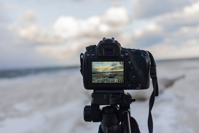 A DSLR camera on a tripod outdoors