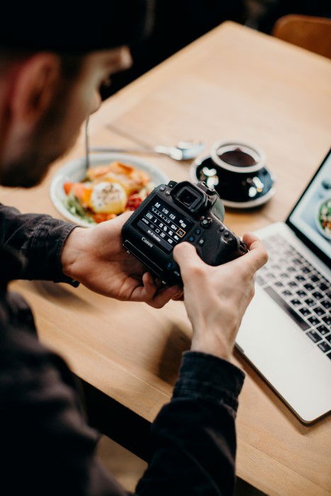 A man changing camera settings on a DSLR