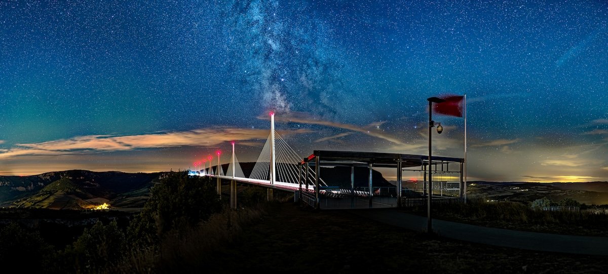 A panoramic of a French viaduct at dusk with the Milky Way
